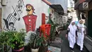 Anak sekolah melintas di depan lukisan tembok atau mural yang menghiasi gang di RT 13 RW 06, Jembatan Lima, Jakarta, Kamis (10/1). Warna-warni mural di pemukiman padat penduduk itu merupakan ide Aryanto selaku Ketua RT 13. (Merdeka.com/Iqbal Nugroho)