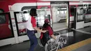 Petugas membantu penyandang disabilitas naiki ke kereta Lintas Rel Terpadu (LRT) di Stasiun LRT Veldrome, Jakarta, Sabtu (27/4). Kegiatan yang diikuti Jakarta Barrier Free Tourism (JBFT) itu untuk mengenalkan LRT lebih dekat, terutama kepada penyandang disabilitas. (Liputan6.com/Faizal Fanani)