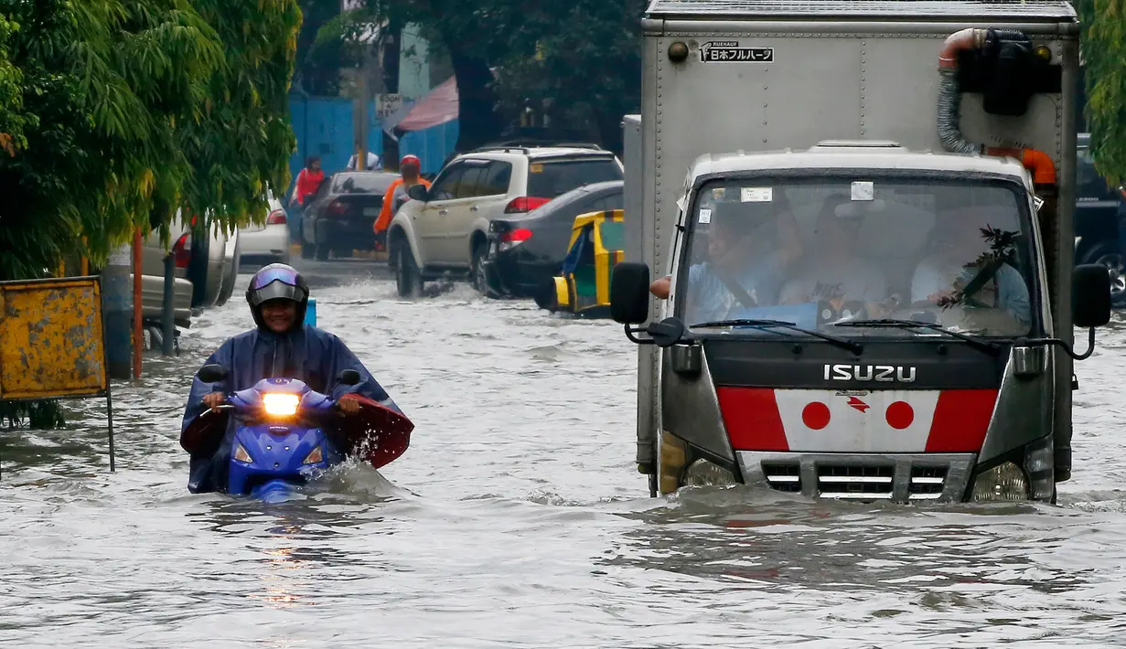 Kendaraan melintasi banjir yang melanda Metropolitan Manila, Filipina, Jumat (20/7). Selain bagian Metropolitan Manila, banjir juga terjadi di provinsi lain. (AP Photo/Bullit Marquez)