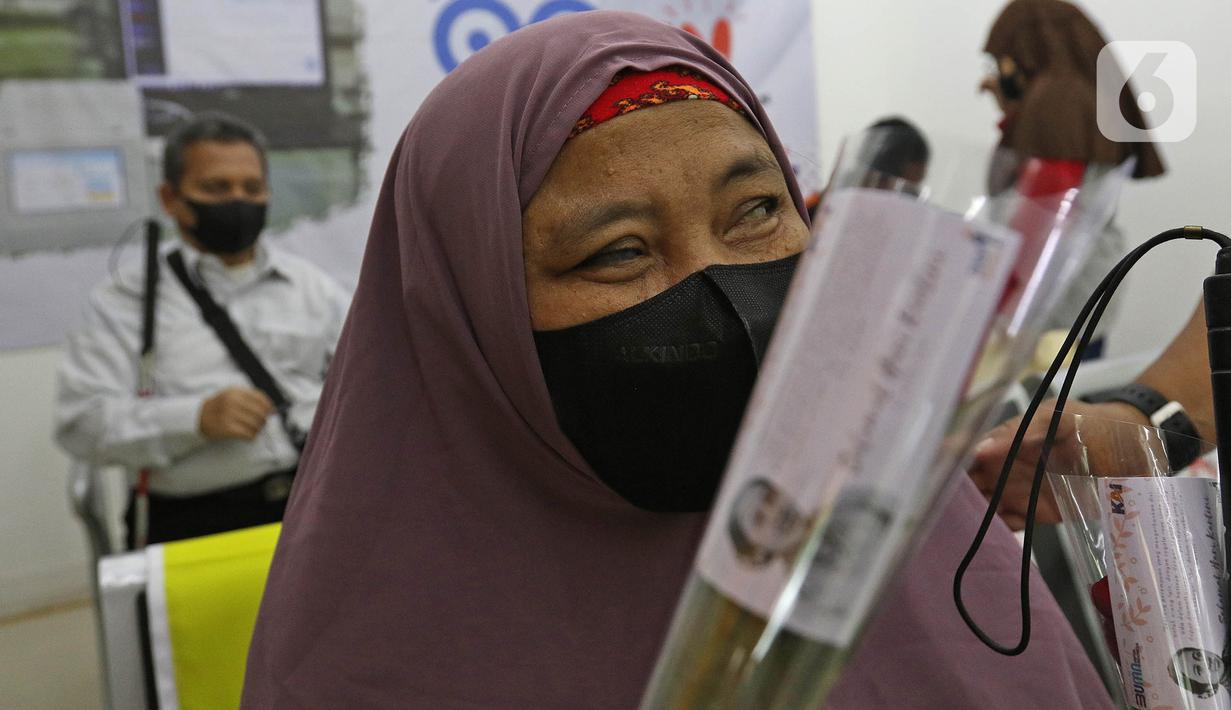 Seorang penumpang menerima bunga dari petugas PT KAI Daop 1 Jakarta yang mengenakan kebaya di Stasiun Gambir, Rabu (21/4/2021). Petugas perempuan itu mengenakan kebaya dan membagikan bunga kepada penumpang guna memeriahkan Hari Kartini yang jatuh pada hari ini. (Liputan6.com/Herman Zakharia)