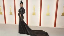 Penyanyi Rihanna berpose untuk fotografer setibanya di karpet sampanye, pengganti karpet merah, Academy Awards ke-95 atau Oscar 2023 di Teater Dolby di Hollywood, California pada Minggu, 12 Maret 2023, waktu setempat.  Tampilan itu menunjukkan ekor gaun panjang yang dramatis dan sayatan menyamping di kedua sisi pinggul Rihanna. (Photo by Jordan Strauss/Invision/AP)