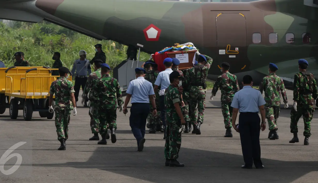 Petugas memindahkan peti jenazah dari pesawat Hercules bernomor ekor 1321 ke pesawat pengganti jenis CN 295, di Lanud Soewondo, Medan, Jumat (3/7). Pemindahan tersebut karena muncul percikan api di bagian kokpit Hercules C-130. (Liputan6.com/Johan Tallo)