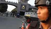 Aparat keamanan berjaga di depan pintu gerbang Mako Brimob Kelapa Dua, Depok, Jawa Barat, Rabu (9/5). Kerusuhan napi teroris yang terjadi di Mako Brimob menyebabkan penjagaan di kawasan tersebut terus diperketat. (Liputan6.com/Immanuel Antonius)