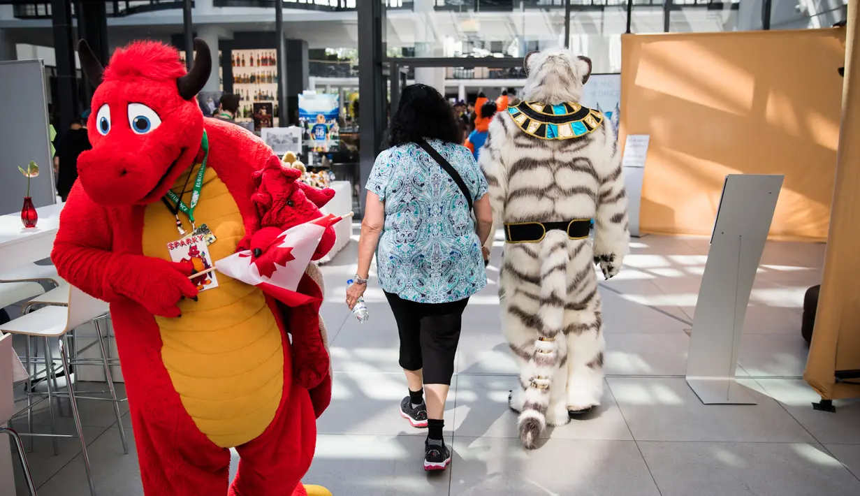 Delegasi dari Kanada membawa bendera negaranya saat mengikuti konvensi Eurofurence di Berlin, Jerman (17/8). Sekitar 2700 delegasi dari berbagai negara ikut berpartisipasi dalam acara tersebut. (AFP Photo/Ganjil Andersen)