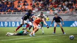 Kiper Timnas Prancis U-17, Paul Argney berusaha mengejar bola dari ancaman pemain Timnas Senegal U-17 pada laga babak 16 besar Piala Dunia U-17 di Jakarta International Stadium, Jakarta Utara, Rabu (22/22/2023) malam WIB. (Bola.com/Bagaskara Lazuardi)