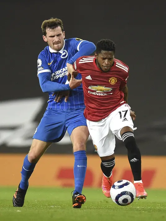 Gelandang Brighton and Hove Albion, Pascal Gross berebut bola dengan gelandang Manchester United (MU), Fred pada pekan ke 30 Liga Inggris di Old Trafford, Senin dinihari WIB (05/04/2021). MU harus bekerja keras sebelum mengalahkan Brighton 2-1. (Oli Scarff/Pool via AP)
