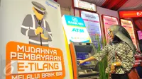 Seorang wanita membayar denda tilang dengan sistem tilang elektronik atau e-tilang melalui mesin ATM BRI di Jakarta, Jumat (16/12). e-Tilang adalah sistem aplikasi pembayaran denda tilang melalui sistem e-banking atau ATM. (Liputan6.com/Angga Yuniar)