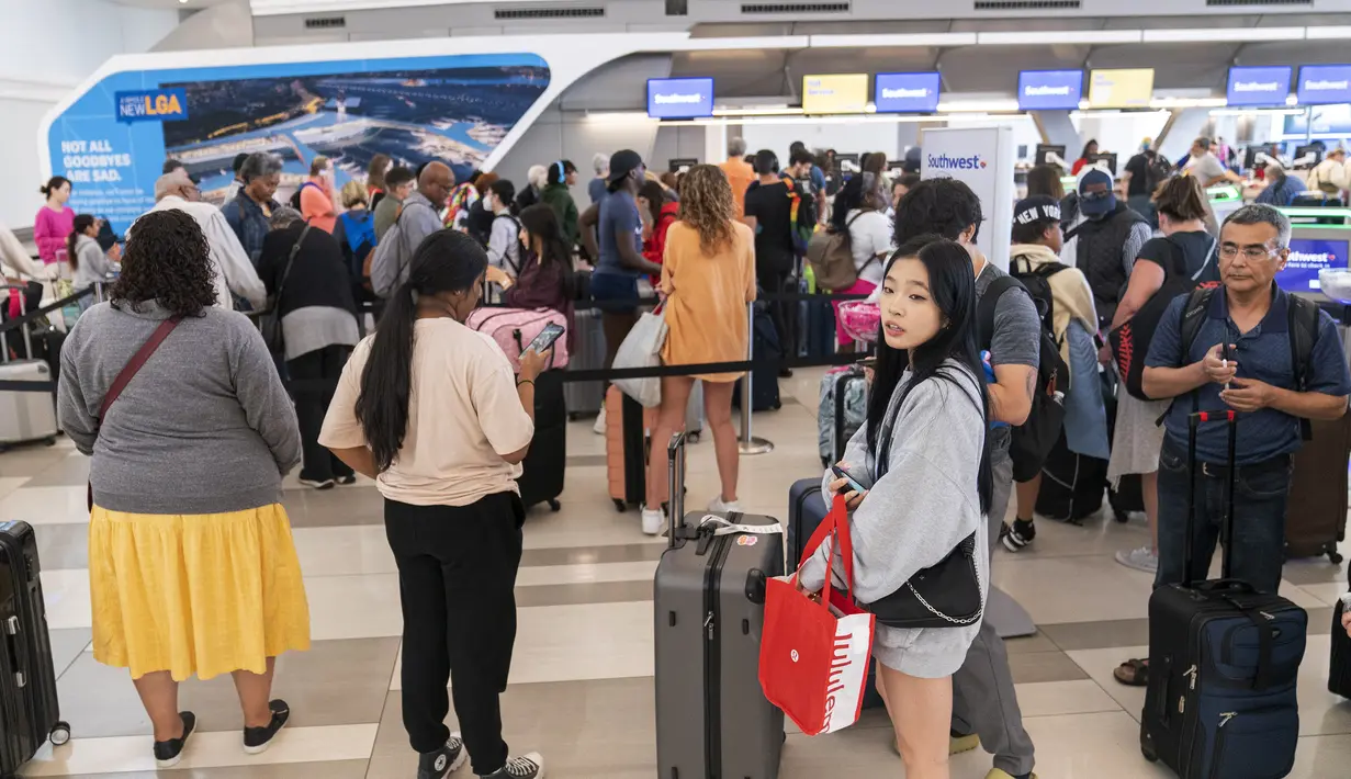 Pelancong berbaris di loket tiket Southwest Airline di area keberangkatan Terminal B di Bandara LaGuardia, di New York, Selasa, 27 Juni 2023. (AP Photo/Mary Altaffer)