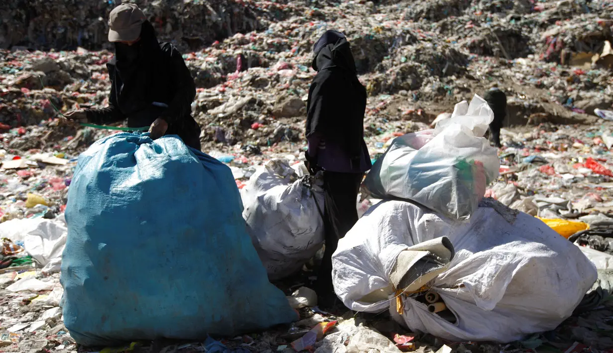 Seorang wanita bersama anaknya mencari sampah di sebuah tempat pembuangan akhir (TPA) di pinggiran Sanaa, Yaman, Rabu (16/11). Setiap hari para bocah di daerah tersebut mengumpulkan sampah untuk didaur ulang atau dijual. (REUTERS/Mohamed al-Sayaghi)