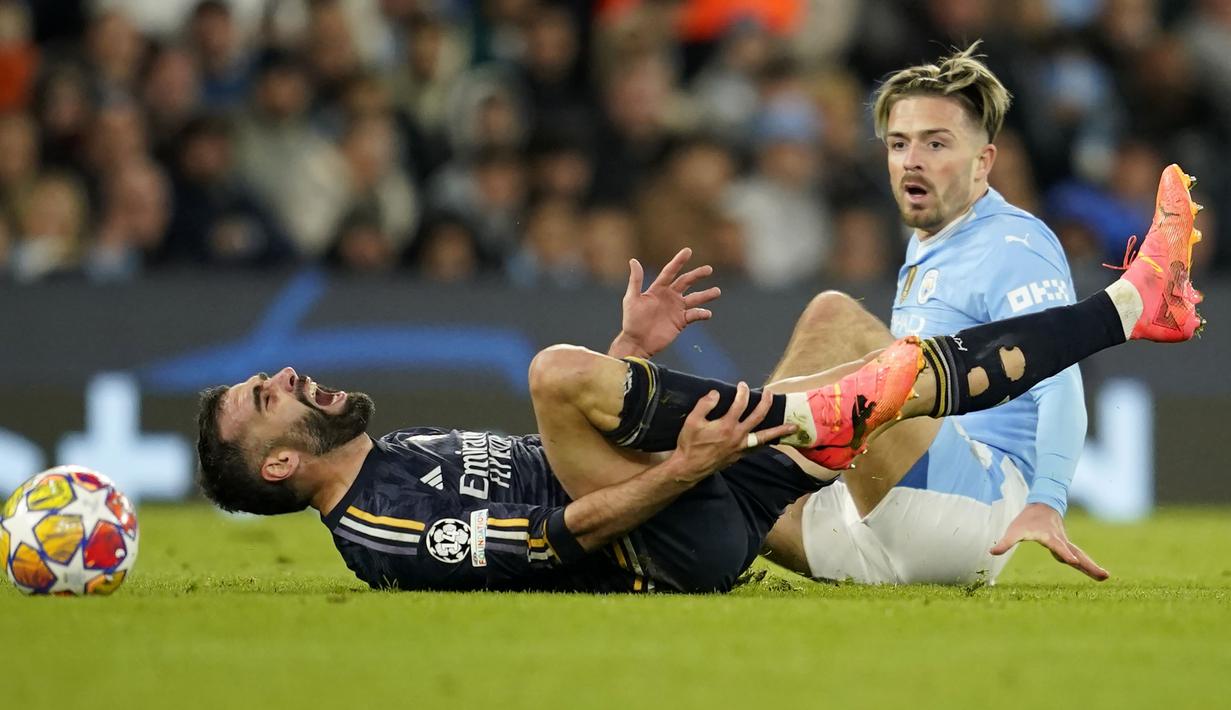 Bek Real Madrid, Dani Carvajal mengerang kesakitan usai terjatuh saat perebutan bola dengan gelandang Manchester City, Jack Grealish pada laga leg kedua perempatfinal Liga Champions 2023/2024 di Etihad Stadium, Manchester, Rabu (18/4/2024). (AP Photo/Dave Thompson)