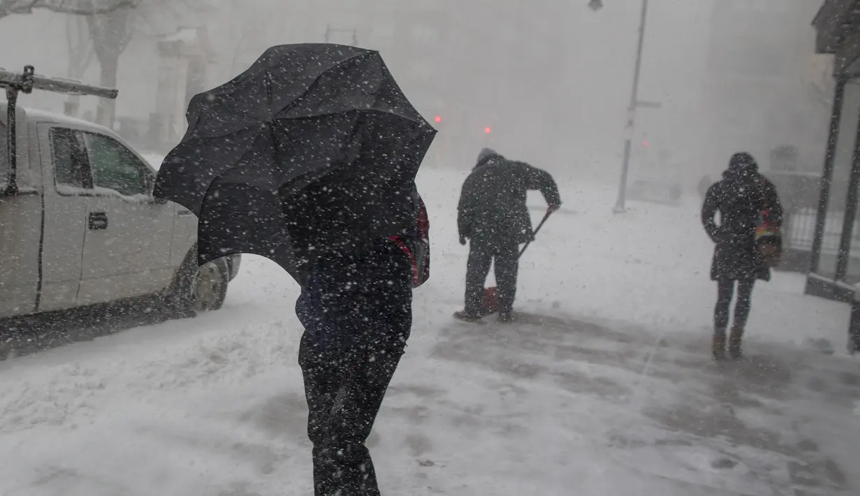 Seorang pria saat diterjang badai salju yang melandawa Massachusetts, Boston, AS (9/2). Cuaca buruk ini membuat jalan di Massachusetts tertutup lapisan es. (Scott Eisen / Getty Images / AFP)