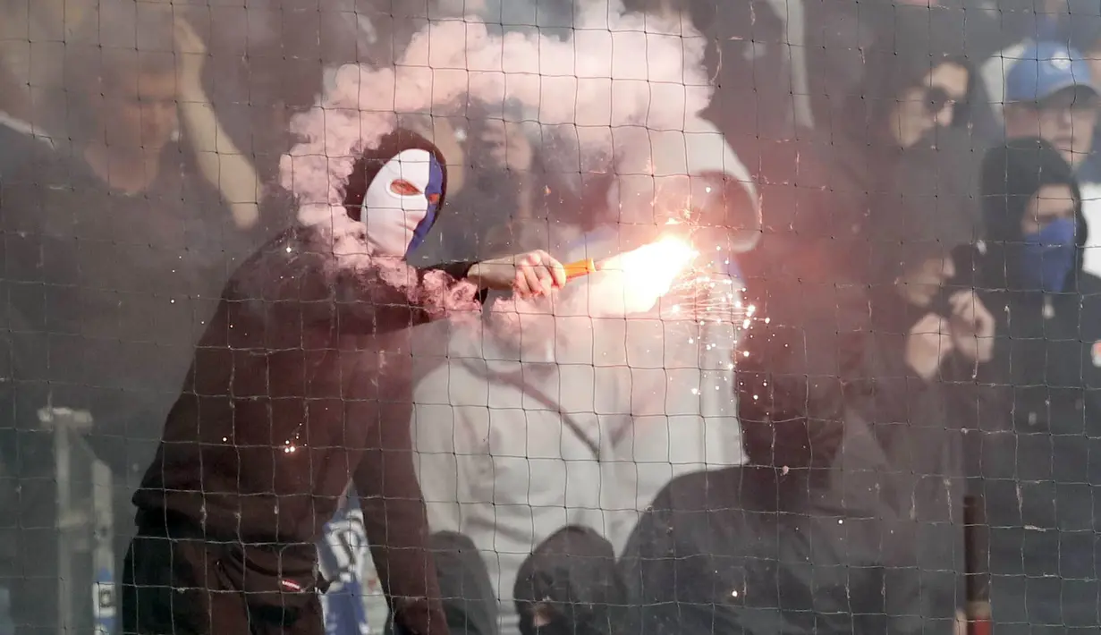 Suporter menyalakan flare saat pertandingan antara Hamburg SV melawan VfL Borussia Moenchengladbach di Volksparkstadion, Sabtu (12/5/2018). Hamburg SV terdegradasi dari Bundesliga Jerman. (AP/Michael Sohn)