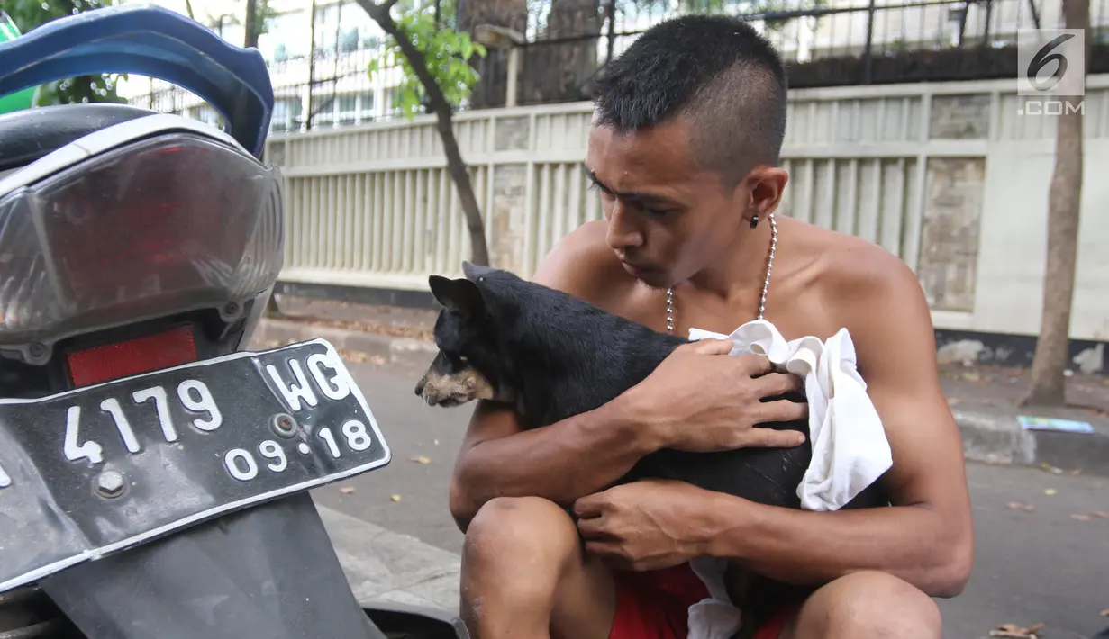Petugas Animal Rescue memeluk anjing setelah diselamatkan di gorong-gorong kali Gresik, Menteng, Jakarta Pusat, Rabu (23/5). Anjing yang terjebak selama 3 hari ini dibawa ke tempat penampungan. (Liputan6.com/Arya Manggala)