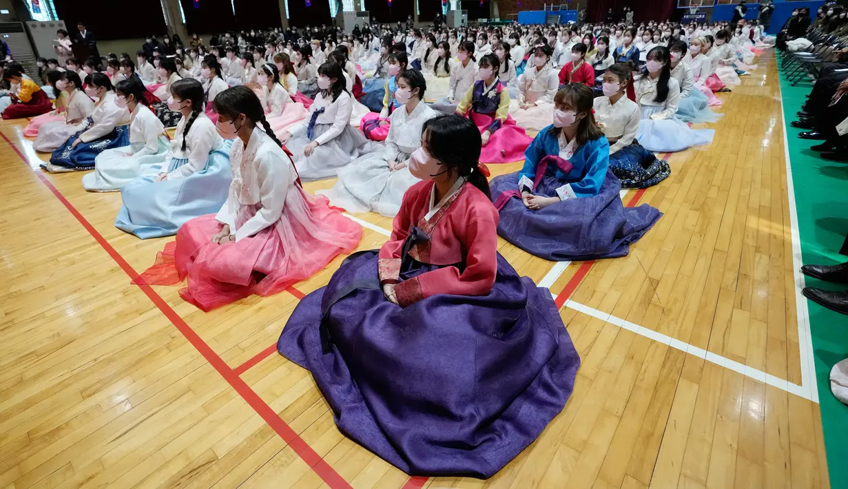 Siswa sekolah menengah atas yang mengenakan pakaian tradisional menghadiri upacara kelulusan dan kedewasaan bersama di Sekolah Menengah Wanita Dongmyung, Seoul, Korea Selatan, 7 Februari 2023. Sekolah menengah atas di Korea Selatan mengajar siswa selama tiga tahun, dari kelas satu (usia 15–16) hingga kelas tiga (usia 17–18), dan siswa biasanya lulus pada usia 17 atau 18 tahun. (AP Photo/Ahn Young-joon)