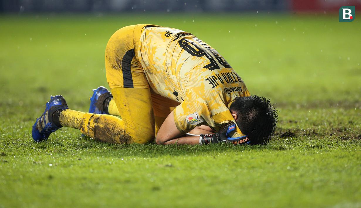 Kiper Rans Cilegon FC, Kurniawan Kartika Ajie melakukan sujud syukur usai kemenangan 3-0 timnnya atas PSIM Yogyakarta dalam laga semifinal Liga 2 2021 di Stadion Pakansari, Bogor, Senin (27/12/2021). (Bola.com/Bagaskara Lazuardi)