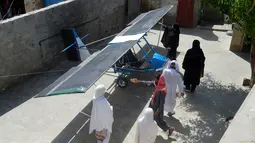 Warga melihat pesawat buatan Muhammad Fayyaz di Desa Tabur, Provinsi Punjab, Pakistan, 8 April 2019. Pesawat kecil tersebut dirakit menggunakan mesin dari alat pemotong aspal, sayapnya dari karung goni, dan roda-rodanya diambil dari roda becak. (ARIF ALI/AFP)