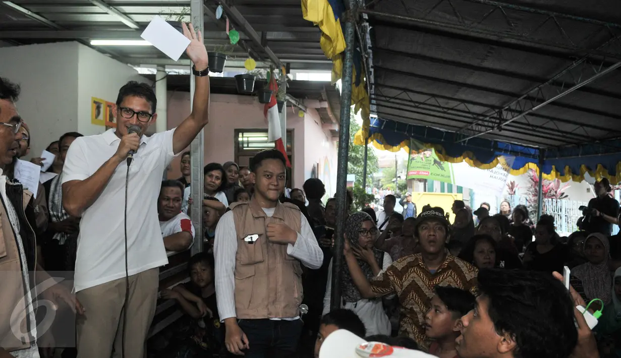 Cawagub DKI Jakarta, Sandiaga Uno memaparkan program KJP Plus kepada warga Jalan Petojo Binatu, Jakarta Pusat, Jumat (17/3). Sandiaga silahturmi dengan warga Petojo dan sosialisasikan programnya bila terpilih nanti. (Liputan6.com/Yoppy Renato)