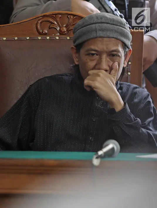 Terdakwa bom Thamrin, Aman Abdurrachman mendengarkan keterangan saksi dalam sidang lanjutan di Pengadilan Negeri Jakarta Selatan, Selasa (27/3). Sidang kasus bom Thamrin ini beragenda mendengarkan keterangan tiga orang saksi (Liputan6.com/Herman Zakharia)