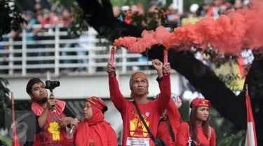 Buruh menyalakan flare saat aksi Hari Buruh di Jalan Medan Merdeka, Jakarta, Senin (5/1). Minta diperbolehkan mendekat ke Istana Negara, buruh menyalakan kembang api dan flare. (Liputan6.com/Yoppy Renato)