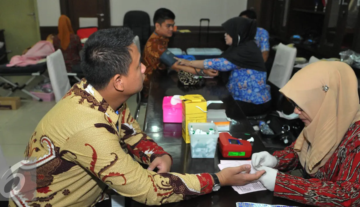 Seorang Petugas bersiap mengambil darah pendonor di ruang rapat BPPK Kemenlu, Jakarta, Jumat (24/7/15). Aksi donor darah tersebut menyambut hari kemerdekaan Indonesia pada tanggal 17 Agustus nanti. (Liputan6.com/Herman Zakharia)