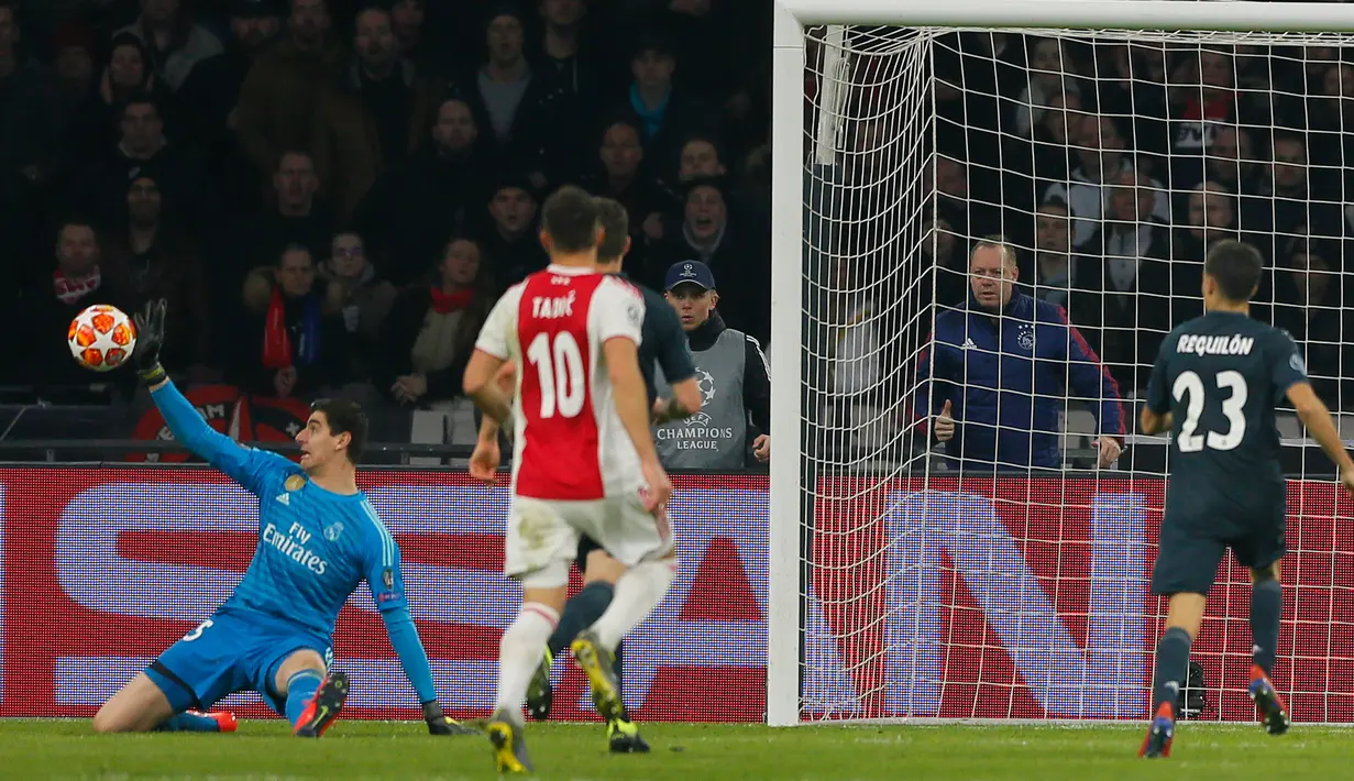 Kiper Real Madrid, Thibaut Courtois menyelamatkan gawangnya saat menghadapi Ajax pada leg pertama 16 besar Liga Champions di Johan Cruijff ArenA, Amsterdam, Rabu (13/2). Real Madrid harus bersusah payah menaklukkan Ajax dengan skor 2-1. (AP/Peter Dejong)