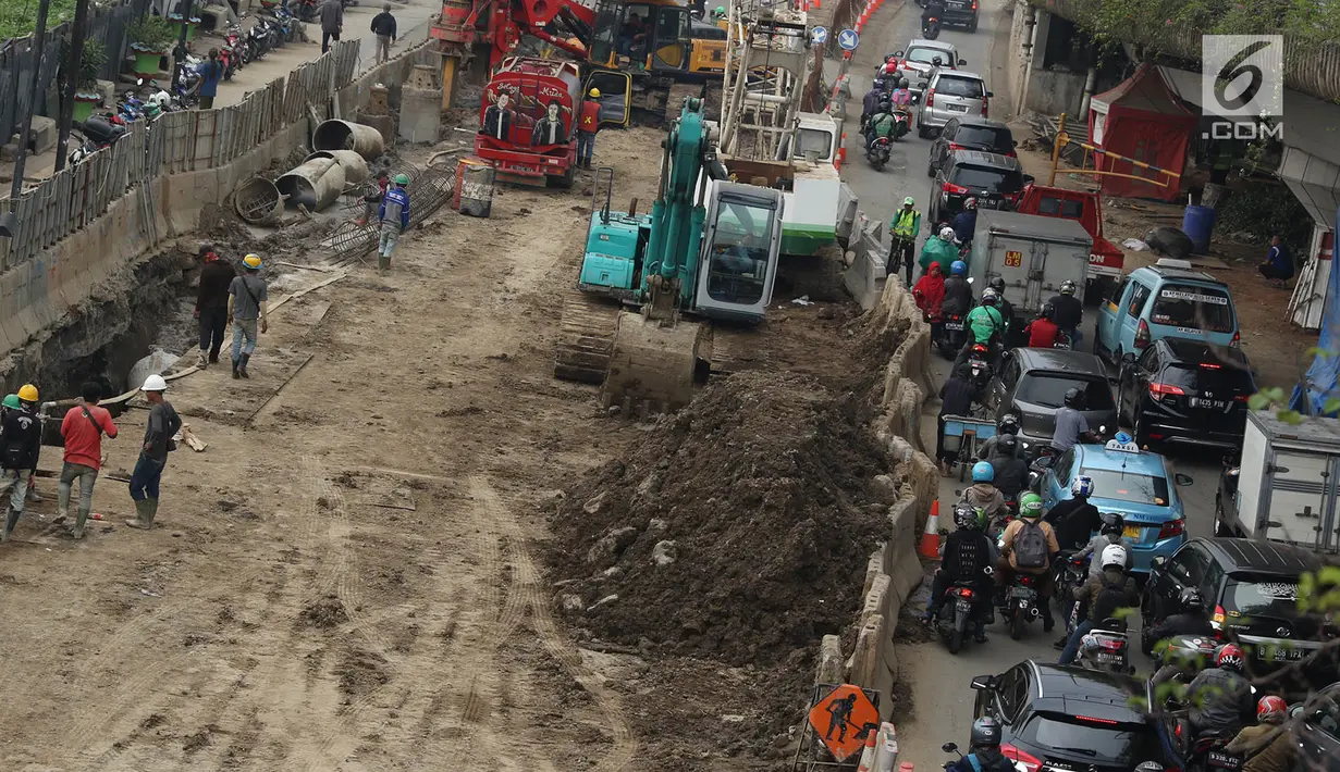 Kendaraan melintas di samping proyek pembangunan terowongan bawah tanah (underpass) Simpang Matraman, Jakarta, Rabu (19/7). Rekayasa lalu lintas terkait pembangunan underpass di kawasan itu akan diuji coba pada 20-27 Juli. (Liputan6.com/Immanuel Antonius)