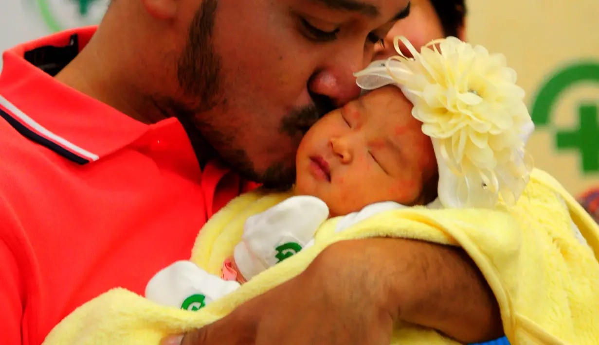Ruben Onsu mencium anak pertamanya, RS Bunda, Jakarta, Minggu (7/6/2015). Ruben memberi nama anak pertamanya Thalia Putri Onsu (Liputan6.com/Faisal R Syam)