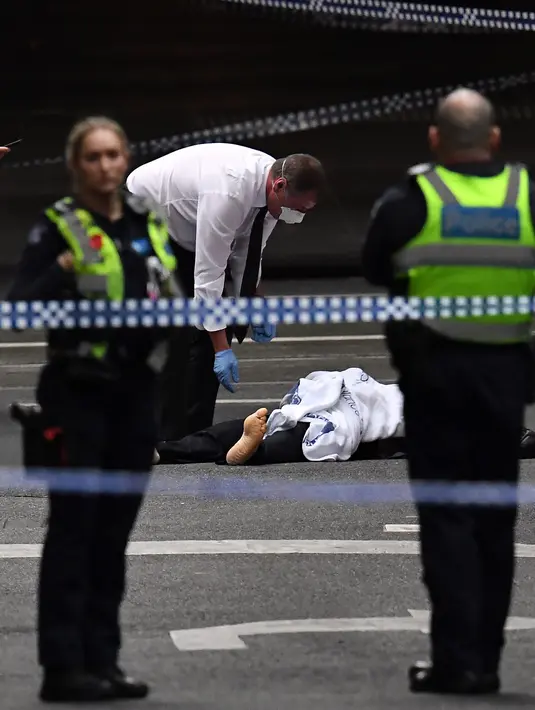 Polisi memeriksa jasad di TKP setelah insiden penikaman di Melbourne, Australia, Jumat (9/11). Akibat penyerangan ini satu orang tewas dan dua lainnya luka-luka. (William WEST/AFP)