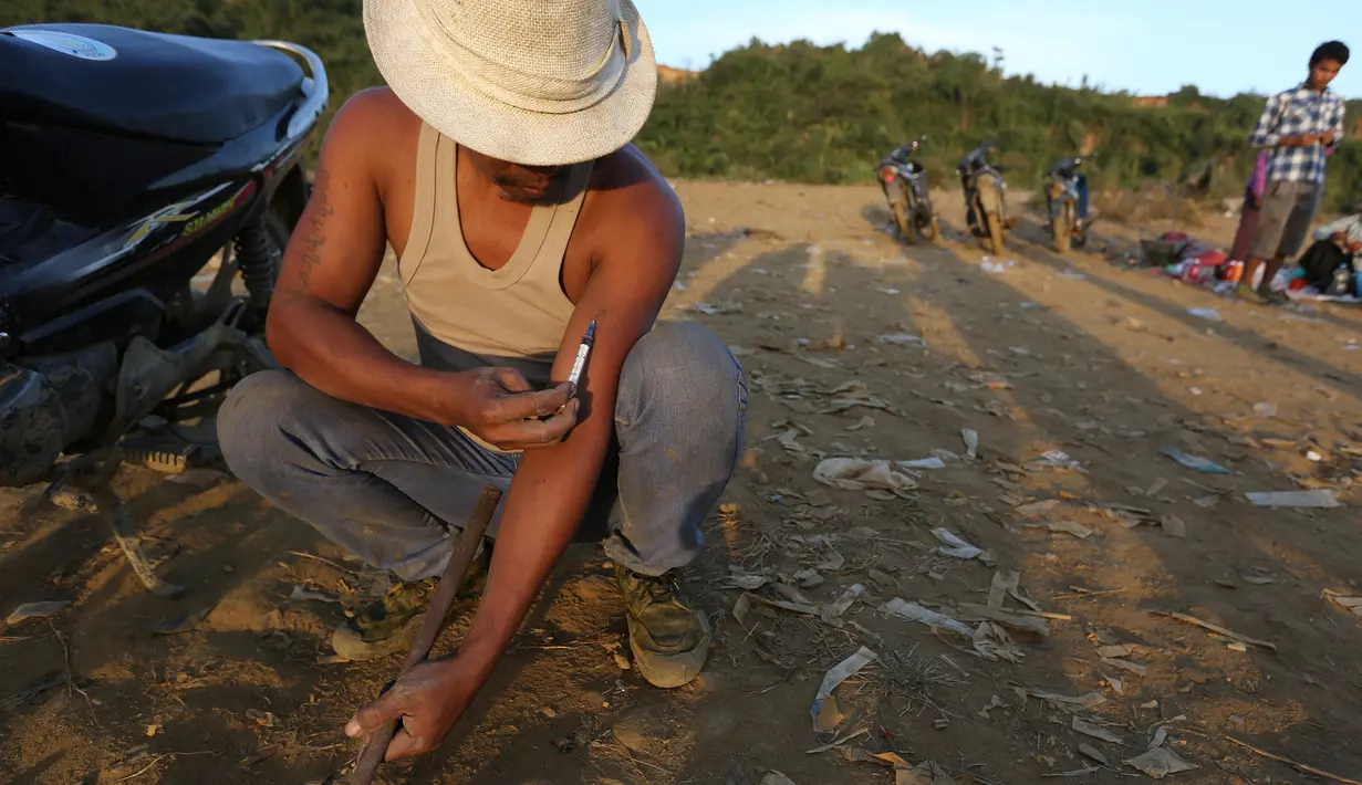 Penambang menyuntikan heroin di Tambang batu giok di Hpakant, Myanmar, 29 November 2015. Kecanduan narkotika sudah merabak pada penambang batu giok untuk digunakan dengan alasan agar kuat mencari dan menemukan gumpalan batu mulia. (REUTERS/Soe Zeya Tun)