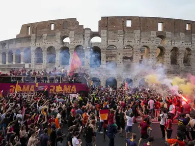 Bus tim AS Roma melaju di tengah kerumunan pendukung yang bergembira saat merayakan kemenangan juara Liga Konferensi Eropa UECL di depan Colosseum di Roma (26/5/2022). AS Roma menjuarai Konferensi Eropa UECL setelah mengalahkan Fayenoord dengan skor tipis 1-0. (AP Photo/Gregorio Borgia)