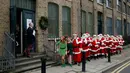 Sejumlah pria mengenakan kostum Santa Claus berbaris saat sesi pemotretan di Ragged School Museum di London (16/11). Sekolah tersebut mengajarkan pria dari usia muda hingga tua mengenai sejarah dan kebudayaan Santa Claus. (AP Photo/Matt Dunham)
