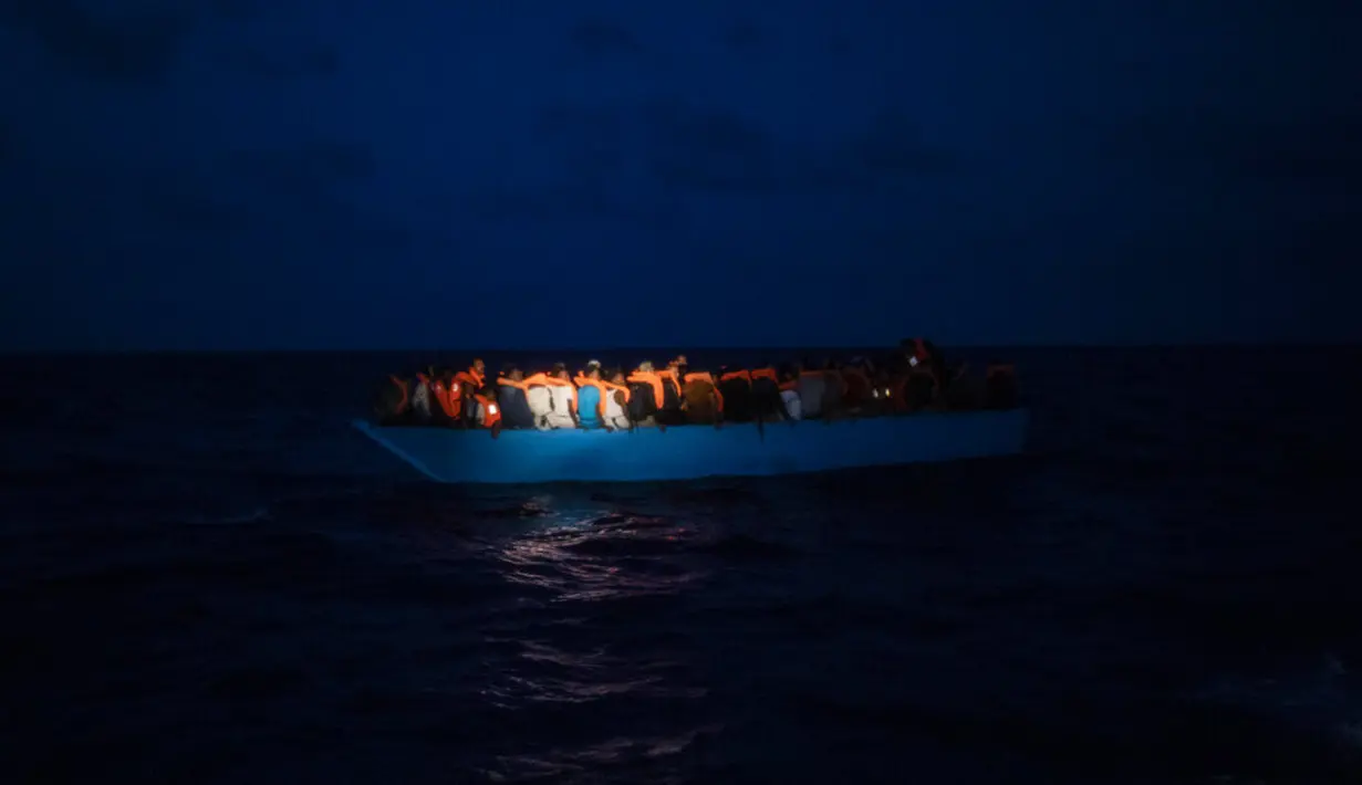 Imigran menunggu petolongan LSM Spanyol Open Arms di Laut Mediterania, Selasa (8/9/2020). Puluhan imigran termasuk wanita dan anak-anak asal Mesir, Maroko, Somalia, dan Sierra Leone menghabiskan lebih dari 20 jam saat melarikan diri dari Libya dengan kapal kayu. (AP Photo/Santi Palacios)