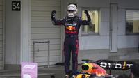 Pembalap Red Bull Max Verstappen merayakan kemenangannya dalam balapan Formula 1 (F1) GP Jepang di Sirkuit Suzuka, Minggu, 9 Oktober 2022. Verstappen memastikan menjadi juara duna F1 dua tahun berturut-turut. (AP Photo/Toru Hanai)