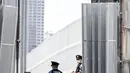 Seorang petugas polisi berjaga di pintu masuk kawasan wisma atlet Olimpiade dan Paralimpiade Tokyo 2020, di Tokyo pada Rabu (14/7/2021). Pembukaan pesta olahraga terbesar di dunia itu tinggal menghitung hari di tengah pandemi COVID-19. (Behrouz MEHRI / AFP)