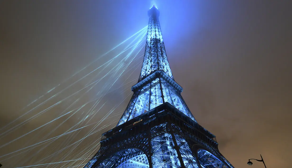 Menara Eiffel yang menjadi ikon kota Paris itu tampak begitu indah dengan bermandikan cahaya warna warni. (Luis Robayo/Pool Photo via AP)