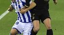 Penyerang Barcelona, Antoine Griezmann berebut bola dengan pemain Real Sociedad, Andoni Gorosabel pada pertandingan La Liga Spanyol di stadion Reale Arena, Spanyol, Senin (22/3/2021). Barcelona kini mengemas 62 poin dari 28 kali berlaga dan berhak menempati posisi kedua. (AP Photo/Alvaro Barrientos)