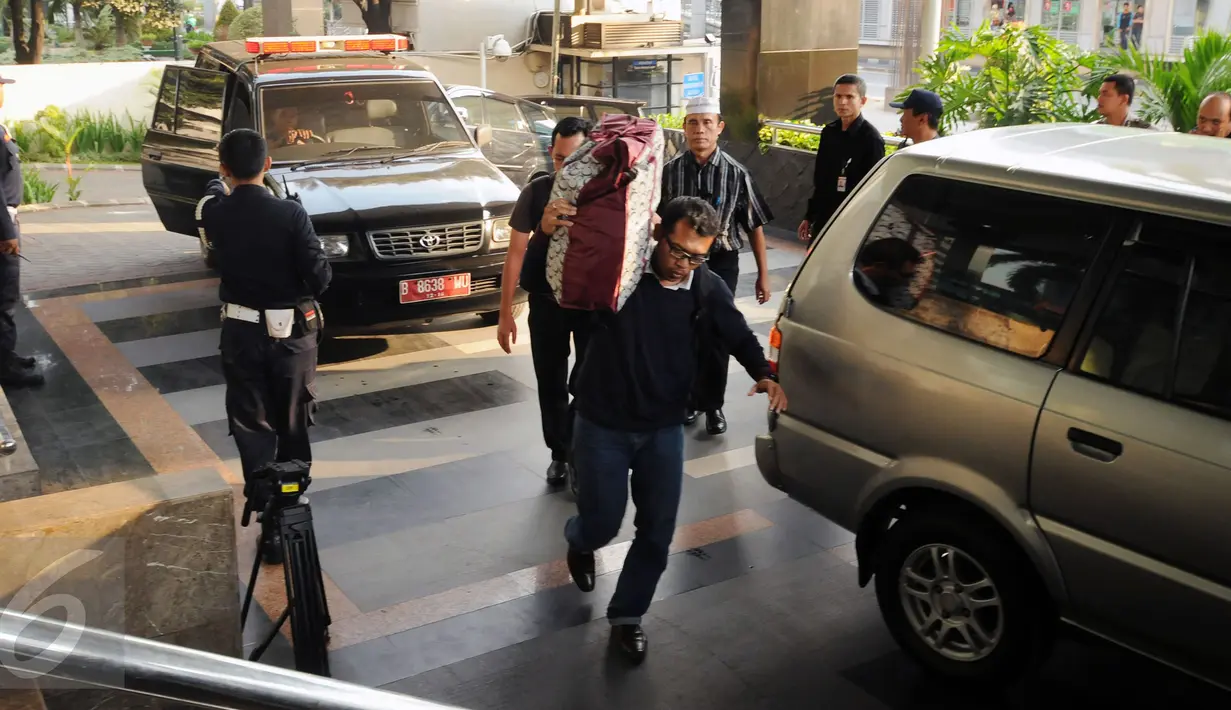 Petugas memanggul tas barang bukti penangkapan untuk diperiksa di gedung KPK Jakarta, Sabtu (20/6/2015). KPK mengamankan empat orang dari Kabupaten Musi Banyuasin berikut uang Rp 2,56 miliar pada Jumat (19/6) malam. (Liputan6.com/Helmi Fithriansyah)