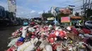 Diketahui, tumpukan sampah tersebut belum terangkut karena kondisi Tempat Pembuangan Akhir (TPA) Cipeucang, Serpong, Kota Tangerang Selatan saat ini sedang dilakukan penutupan sementara. Tampak dalam foto, pengendara melintas di dekat tumpukan sampah diletakkan pada salah sisi satu ruas jalan di kawasan Pasar Manggis, Ciputat, Tangerang Selatan, Senin (15/12/2025). (merdeka.com/Arie Basuki)