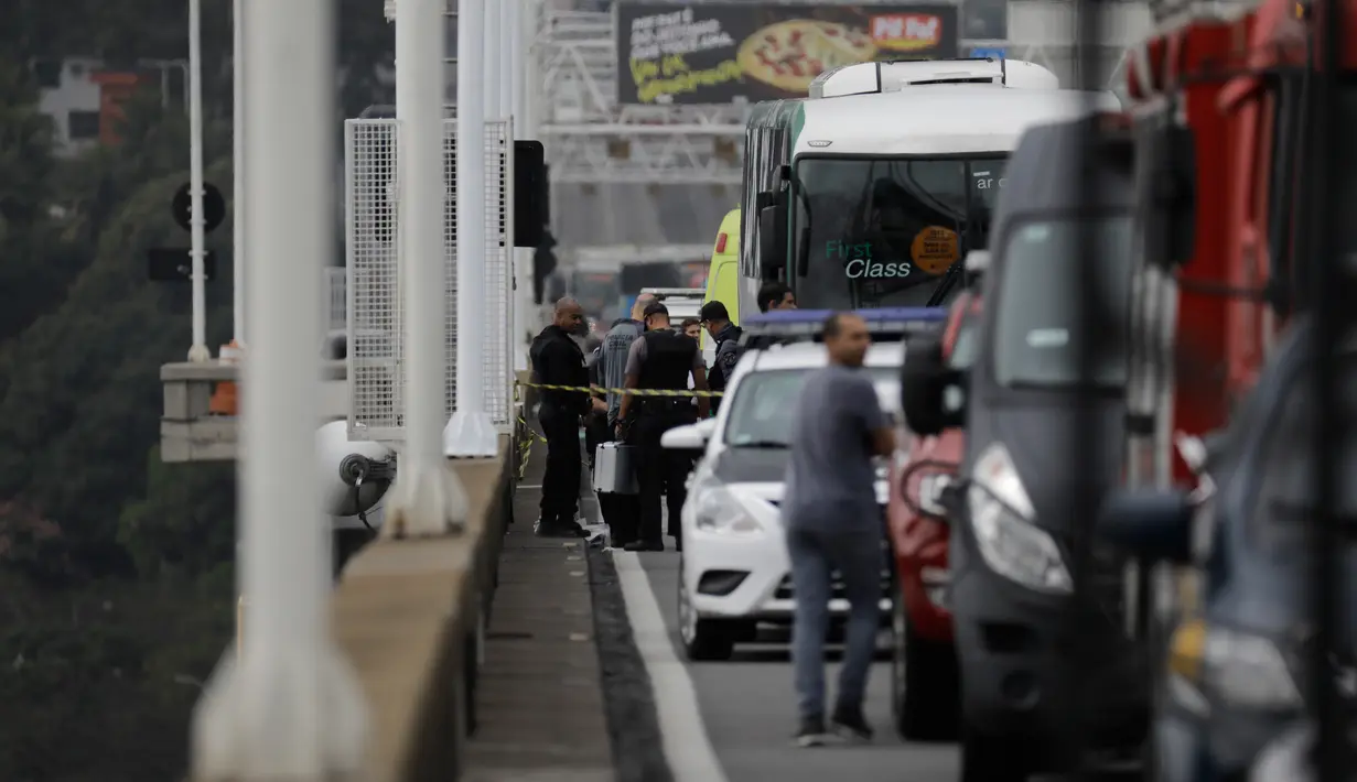 Polisi mengamankan bus yang disandera seorang pria bersenjata di jembatan yang menghubungkan Kota Niteroi dengan Rio de Janeiro, Brasil, Selasa (20/8/2019). Penyandera berhasil dilumpuhkan oleh penembak jitu dari pasukan elite dan semua sandera selamat. (AP Photo/Leo Correa)