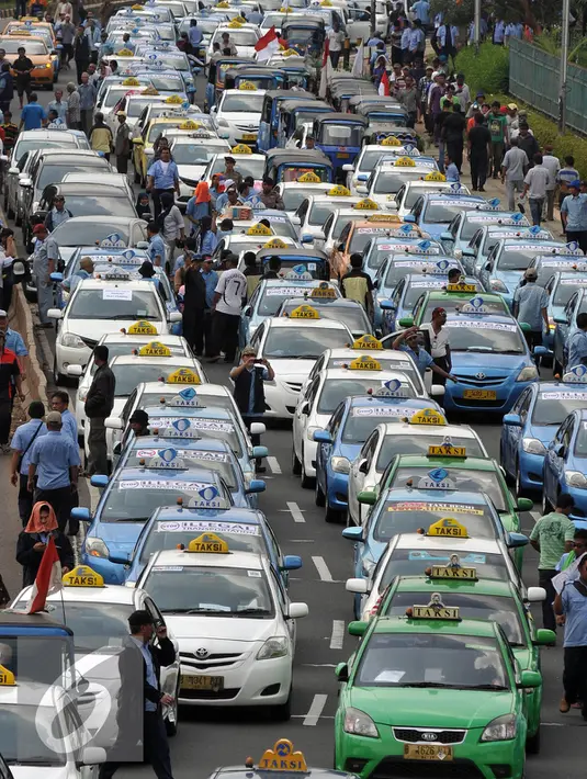 Sejumlah Sopir taksi saat melakukan demo di Jakarta, Selasa (22/3). Selain melakukan demo supir taxi tersebut melakukan sweeping ke sopir taksi yang beroperasi di dalam tol, dan membakar ban.(Liputan6.com/Johan Tallo)
