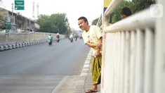 Warga menerobos celah pagar pembatas jalan di depan Stasiun Pasar Minggu, Jakarta, Rabu (16/10/2019). Jauhnya jembatan penyeberangan orang (JPO) membuat warga memanfaatkan celah pagar pembatas tersebut sebagai akses menyeberang, meski berbahaya bagi keselamatan. (Liputan6.com/Immanuel Antonius)