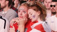 Dua orang fans tampak sedih usai timnas Inggris gagal melaju ke final Piala Dunia di Hyde Park, London, Rabu (11/7/2018). Kroasia menang 2-1 atas Inggris. (AP/Matt Dunham)