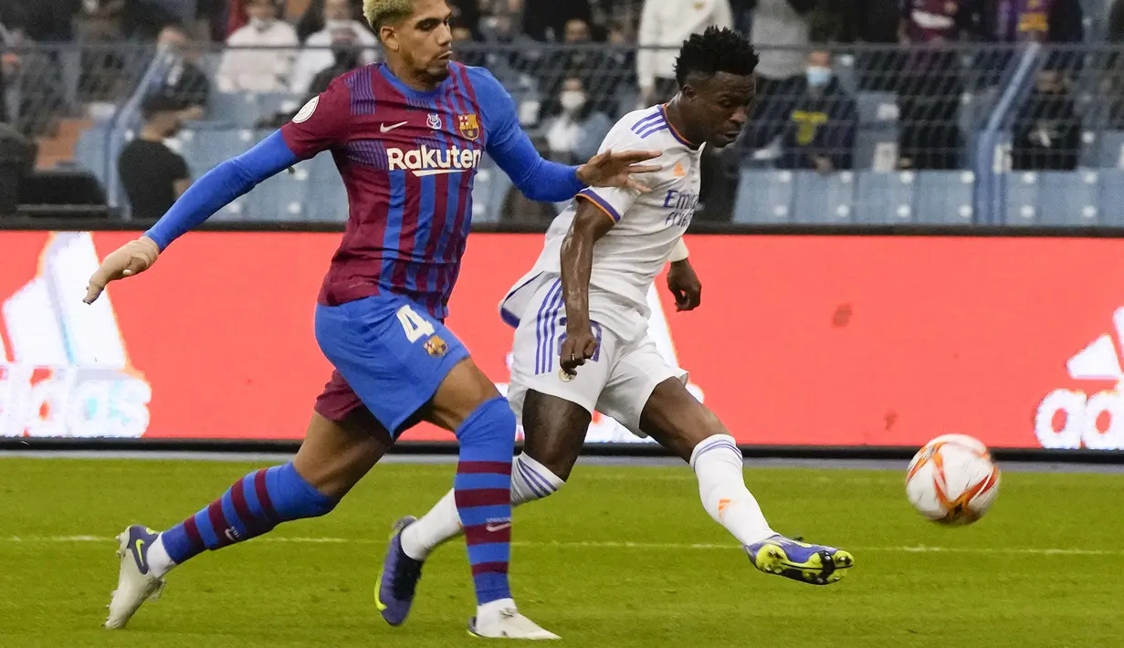 Real Madrid berhasil memimpin kedudukan pada menit ke-25. Berawal dari umpan daerah yang dikirim Karim Benzema, Vinicius yang berlari di sisi kiri tak mampu dihentikan oleh Ronald Araujo dan berhasil melepaskan tembakan keras. (AP/Hassan Ammar)