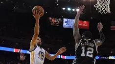 Pemain Warriors, Stephen Curry (30) berusaha memasukan bola dari kawalan LaMarcus Aldridge (12) saat bertanding pada gim pertama final Wilayah Barat playoffs NBA 2017 di Oakland, California (14/5). (Thearon W. Henderson/Getty Images/AFP)