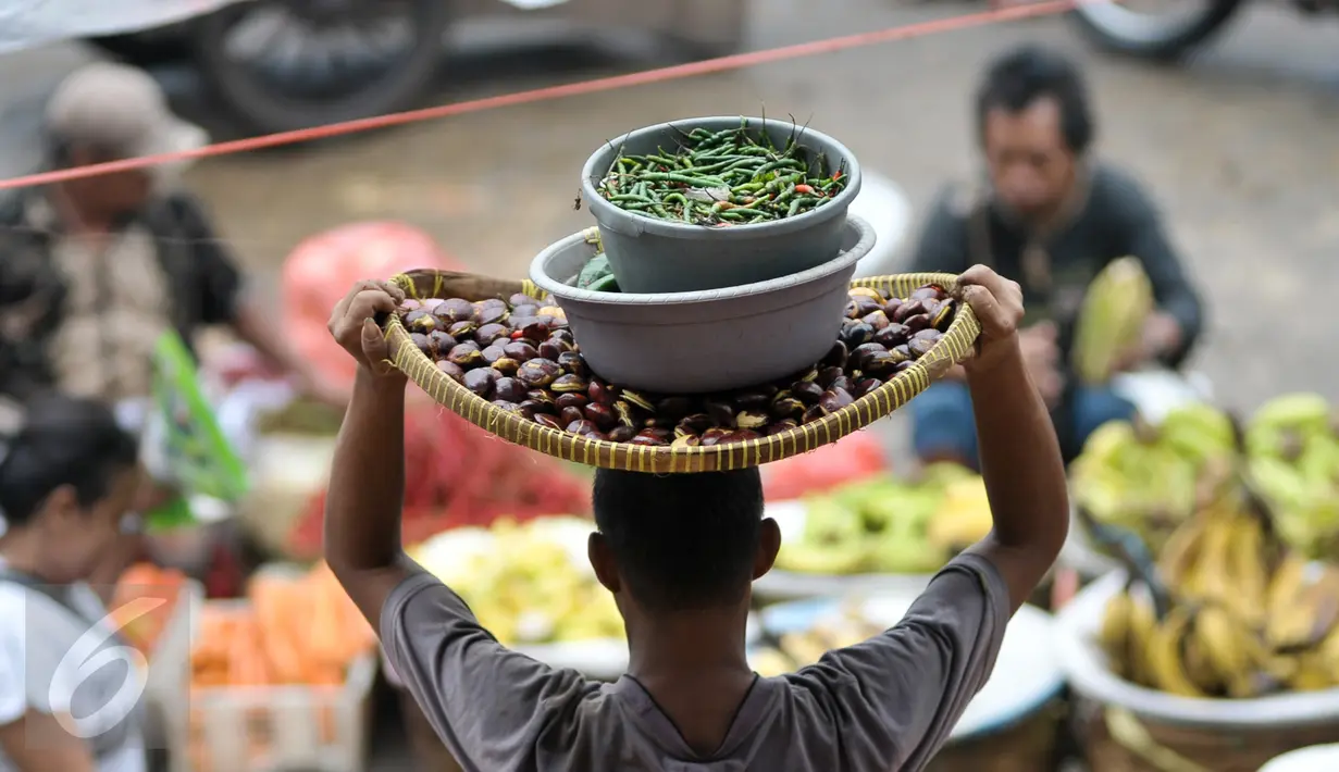  Pedagang membawa cabai di pasar tradisional, Jakarta, Senin (10/10). Kenaikan harga cabai keriting terimbas kondisi cuaca yang kurang baik sehingga membuat pasokan berkurang. (Liputan6.com/Yoppy Renato)