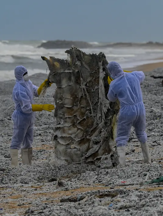 Tentara Angkatan Laut Sri Lanka menghilangkan puing-puing dari kapal kontainer MV X-Press Pearl yang terdampar di sebuah pantai di Kolombo, Jumat (28/5/2021). Kapal berbendera Singapura yang membawa 25 ton asam nitrat itu terbakar di lepas pantai Kolombo. (Ishara S. KODIKARA/AFP)