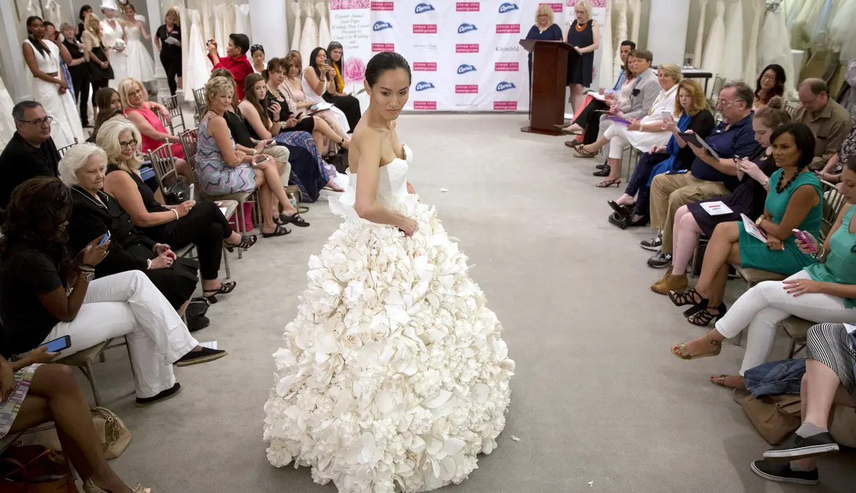 Model berjalan mengenakan 'Garden Party' karya Carol Touchstone saat kontes gaun pengantin yang terbuat dari tisu toilet di Butik Kleinfled's Bridal, New York, 17 Juni 2015. (REUTERS/Brendan McDermid)