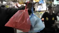 Warga menunjukkan barang belanjaan yang dibawa menggunakan kantong plastik sekali pakai di Pasar Tebet Barat, Jakarta, Kamis (6/2/2020). Masih banyak pedagang maupun pembeli yang menggunakan kantung plastik sebagai tempat bawaan membawa belanjaan. (merdeka.com/Iqbal S Nugroho)