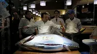 Kiyoshi Kimura usai memotong tuna sirip biru dengan berat 200 kg di Tsukiji, Tokyo, Jepang, Selasa (5/1). Tuna sirip biru yang berhasil direbut Kimura menjadi yang terberat dan termahal pada lelang ikan pertama 2016. (REUTERS/Toru Hanai)