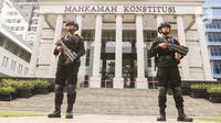 Polisi bersenjata lengkap melakukan pengamanan di Gedung Mahkamah Konstitusi (MK), Jakarta, Selasa (7/11/2023). (Liputan6.com/Angga Yuniar)